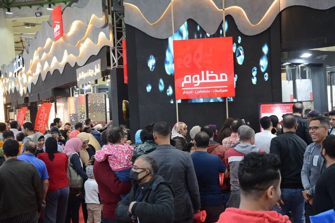 A packed aisle of visitors walking between exhibitor stands